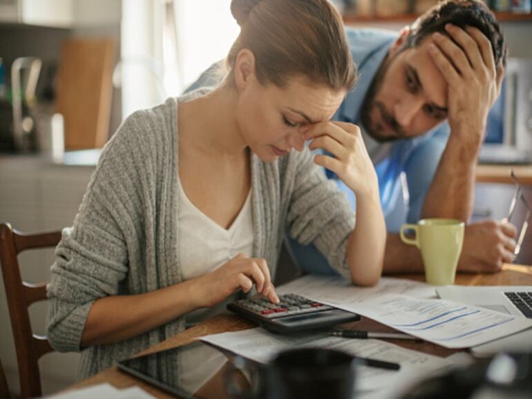 Jóvenes hacen cuentas con cara de preocupación