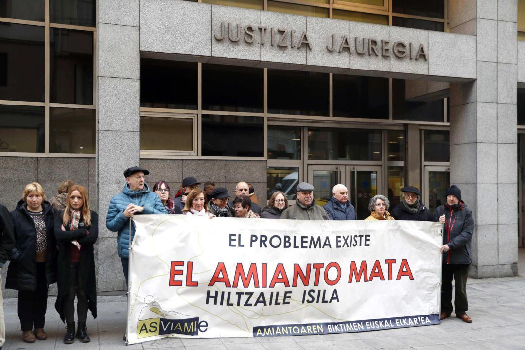 Miembros de la asociación vasca de víctimas del amianto ASVIAMIE durante la concentración este martes para expresar su apoyo a un trabajador que reclama 320.000 euros a empresas como Iberdrola, Petronor y Repsol por no informarle de los riesgos de la manipulación del amianto en su puesto de trabajo, que le hizo enfermar.