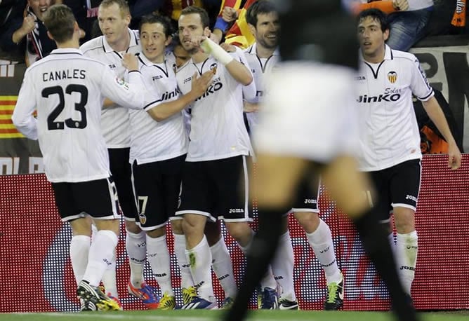 El delantero del Valencia CF Roberto Soldado celebra su gol, segundo de su equipo, con sus compañeros durante el partido ante el Levante en Mestalla.