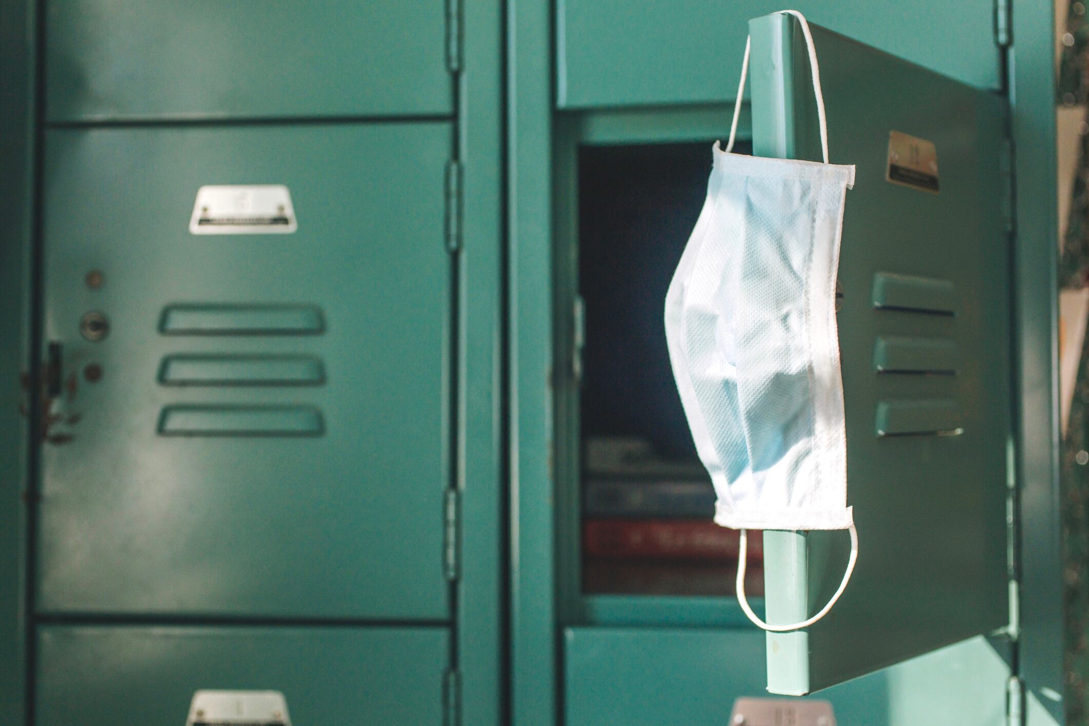 Surgical mask hanging inside school on locker. School re-openings were a controversial part of the Coronavirus pandemic, COVID-19 pandemic during 2020 and 2021.