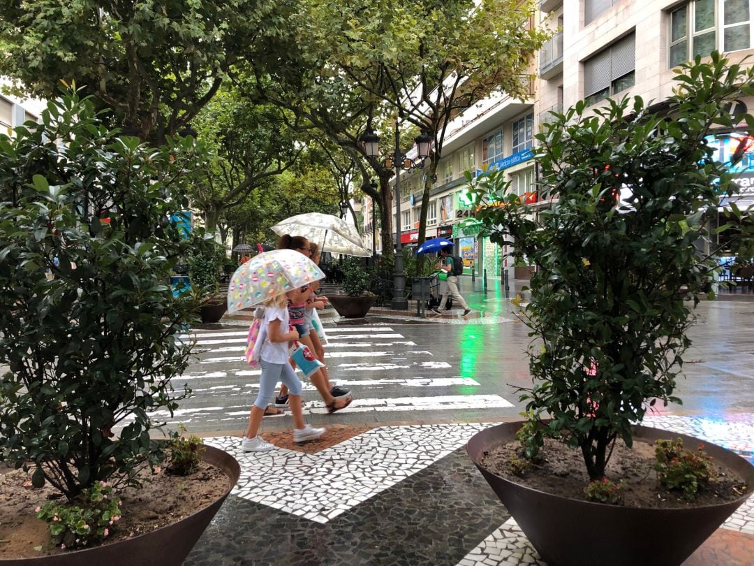 Una familia se refugia de la lluvia en Gandia.