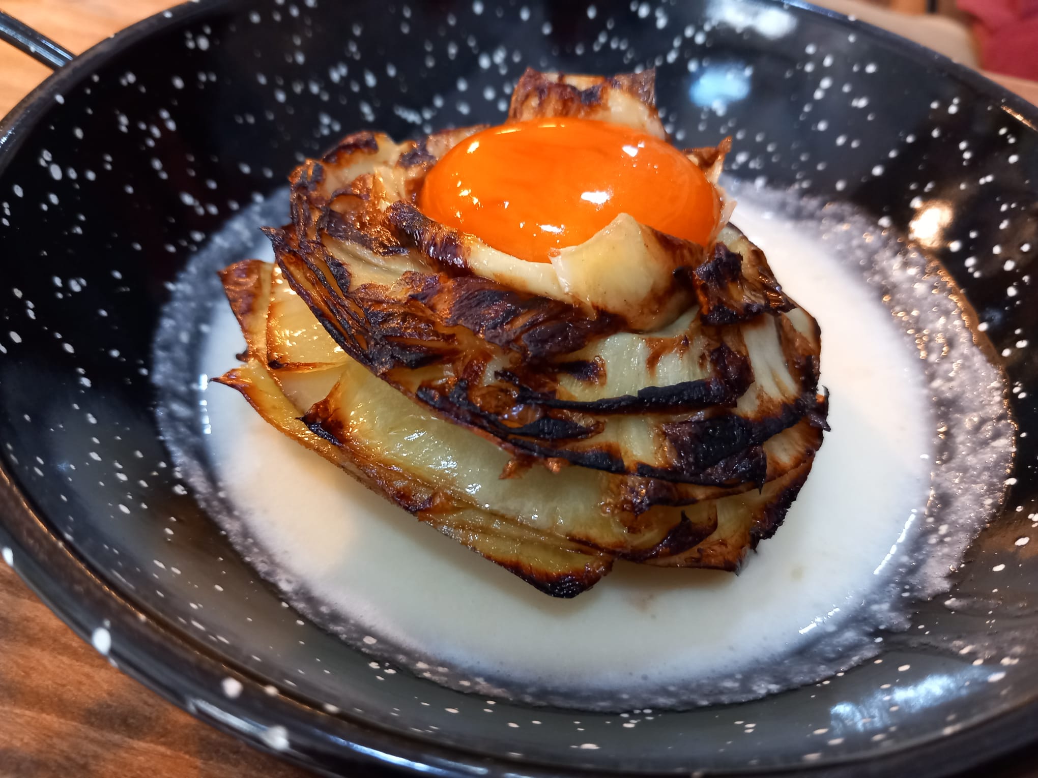 Flor de alcachofa con crema de jamón y yema curada