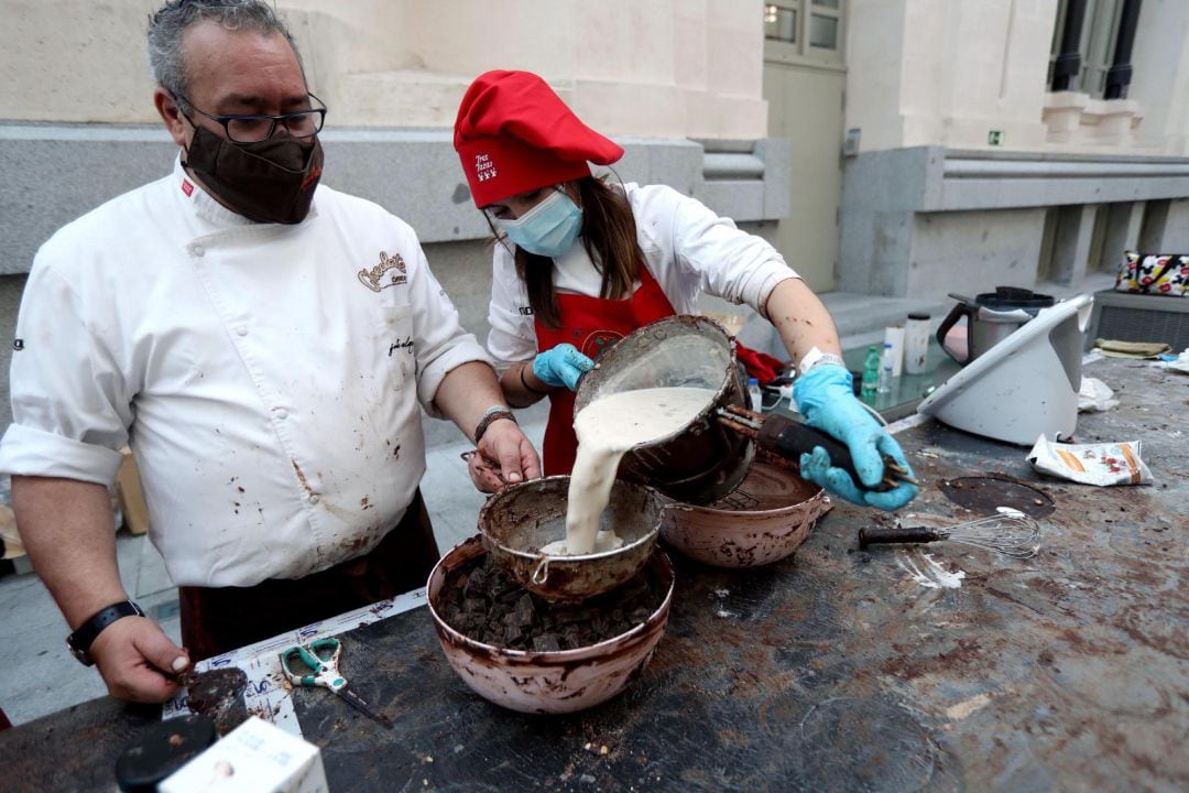 El maestro pastelero Justo Almendrote (i), trabaja en la elaboración del turrón de chocolate más largo del mundo, de 50 metros de largo, y cuyos beneficios se destinarán a fines sociales de la Fundación Esperanza y Alegría. 