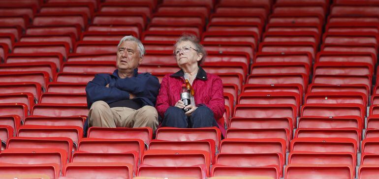 Dos aficionados en la grada vacía de Old Trafford