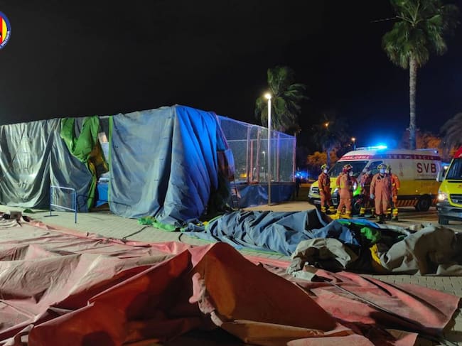 Bomberos junto al hinchable levantado por el viento en la Feria de Mislata