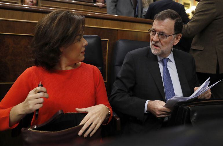 El presidente del Gobierno, Mariano Rajoy (d), conversa con la vicepresidenta, Soraya Sáenz de Santamaría (i), al inicio de la sesión de control al Gobierno