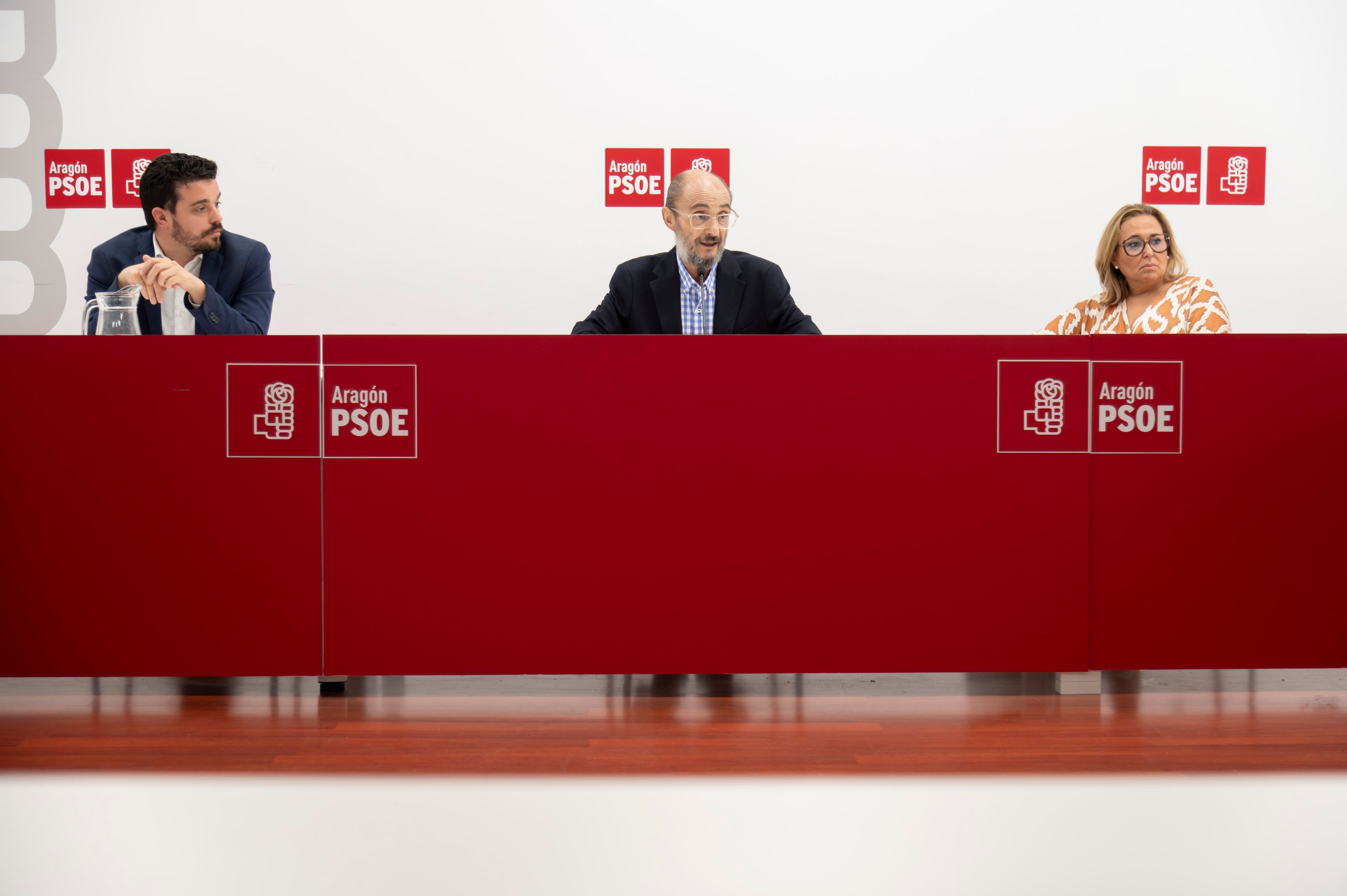 Javier Lambán, en el centro, junto a Mayte Pérez y Darío Villagrasa. PSOE