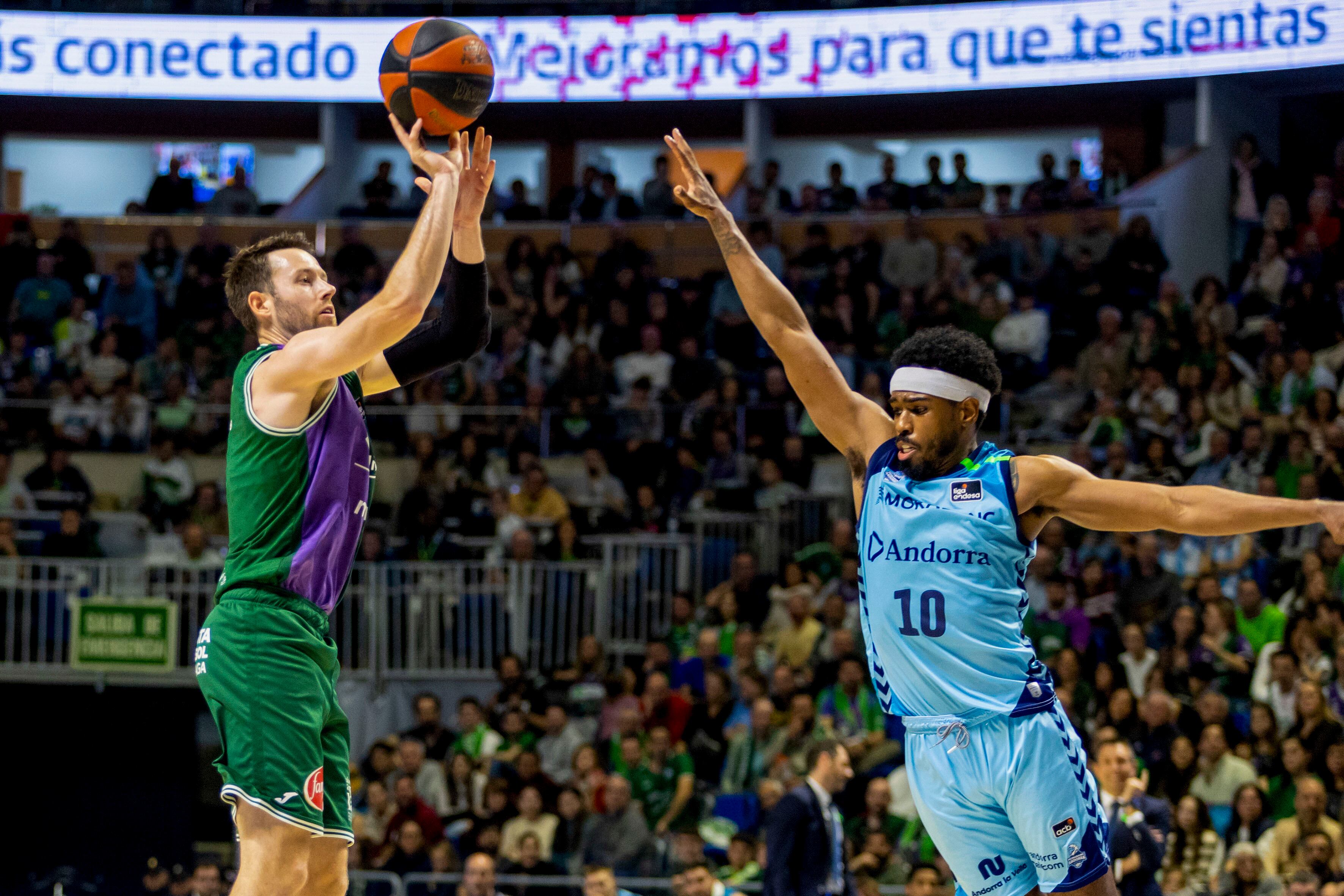 El jugador de l'Unicaja Tyler Kalinoski (i) llança a cistella davant Jerrick Harding, del Morabanc, durant el partit de la Lliga Endesa de bàsquet que Unicaja i Morabanc Andorra han disputat aquest dissabte al Palacio de los Deportes José María Martín Carpena.