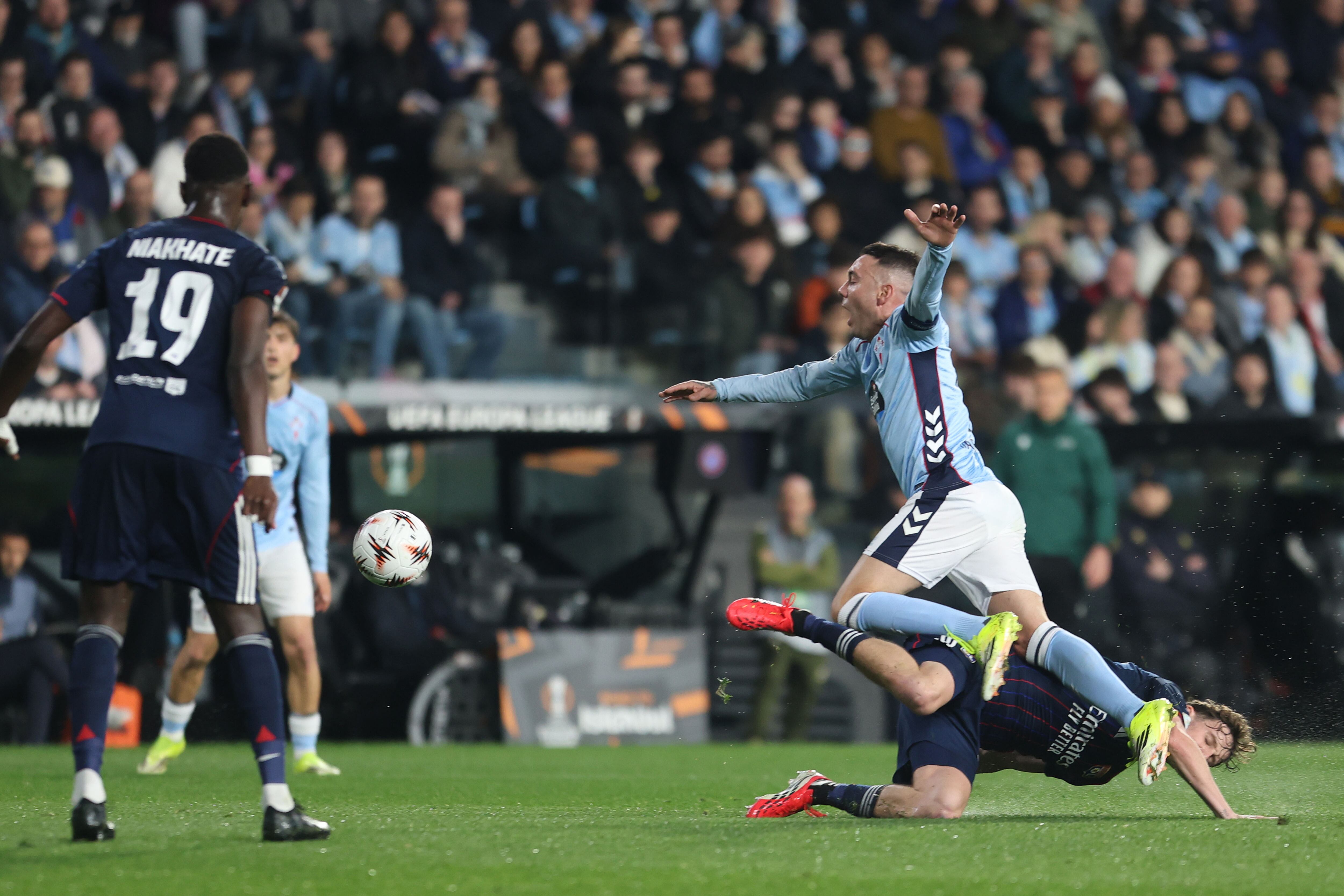 VIGO (PONTEVEDRA), 12/03/2026.- El delantero del Celta Iago Aspas (d, arriba) cae ante Nicolás Tagliafico (d, abajo), del Olympique, durante el partido de ida de los octavos de final de la Liga Europa que Celta y Olympique de Lyon disputan este jueves en el estadio de Balaídos, en Vigo. EFE/Salvador Sas