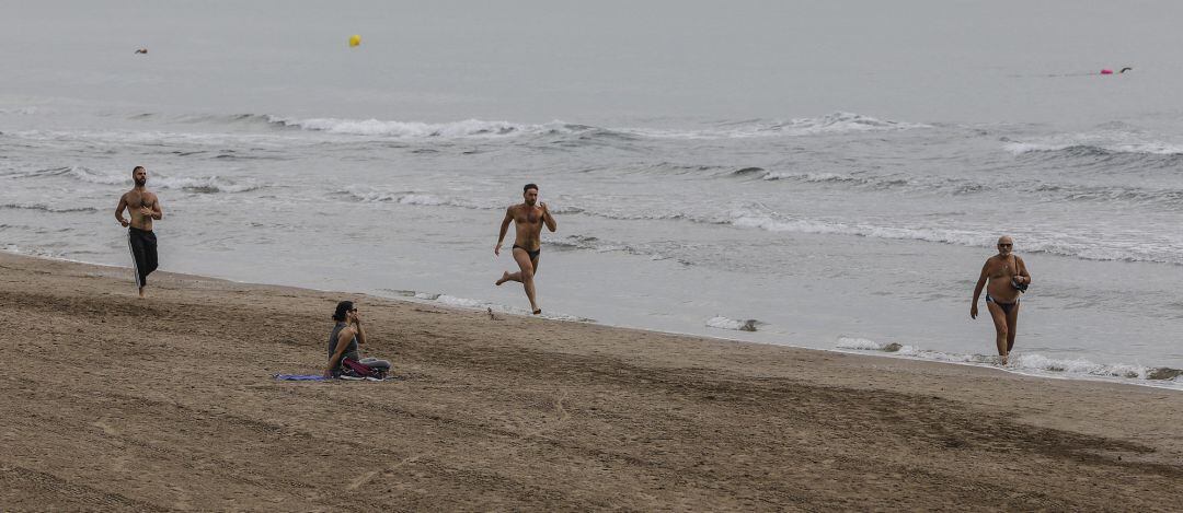 Varias personas caminan y hacen deporte en la playa