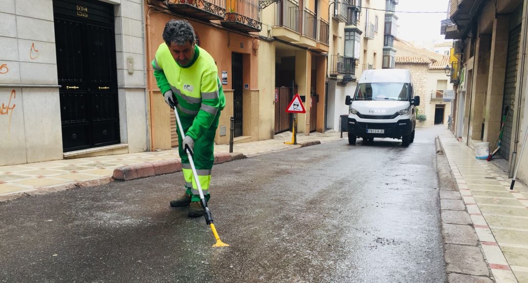 Un operario retira la cera de la calle de la calle Muñoz Garnica.