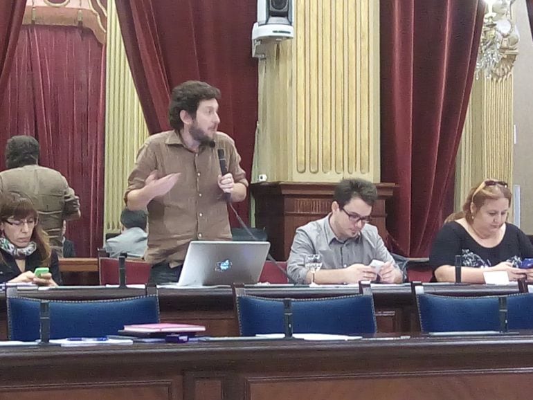 Alberto Jarabo, diputado de Podemos, defiende su moción mientras sus compañeros están pendientes del móvil.