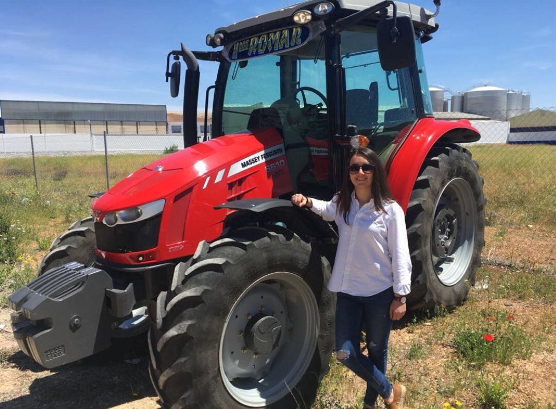 Cristina junto al tractor con el que faenan en su explotación de Tomelloso