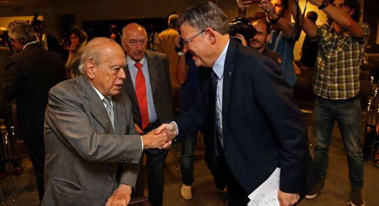 El presidente de la Generalitat Valenciana, Ximo Puig (d), saluda al expresidente catalán, Jordi Pujol (i), en la sede del Circulo de Economía, tras pronunciar la conferencia &quot;Competitividad mediterránea y gestión de la diversidad&quot;.