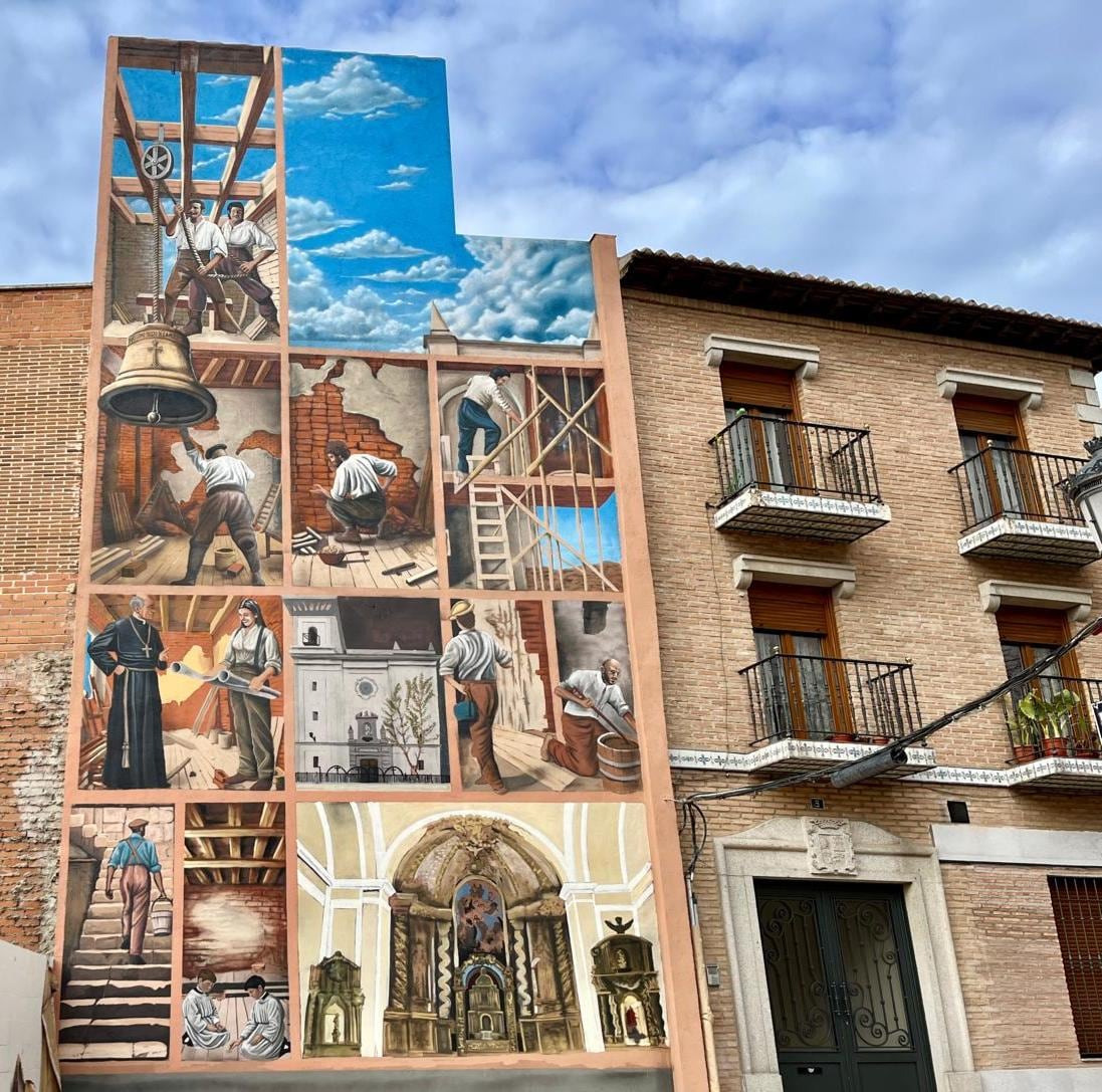 El mural se sitúa justo frente a la iglesia cuya construcción recrea