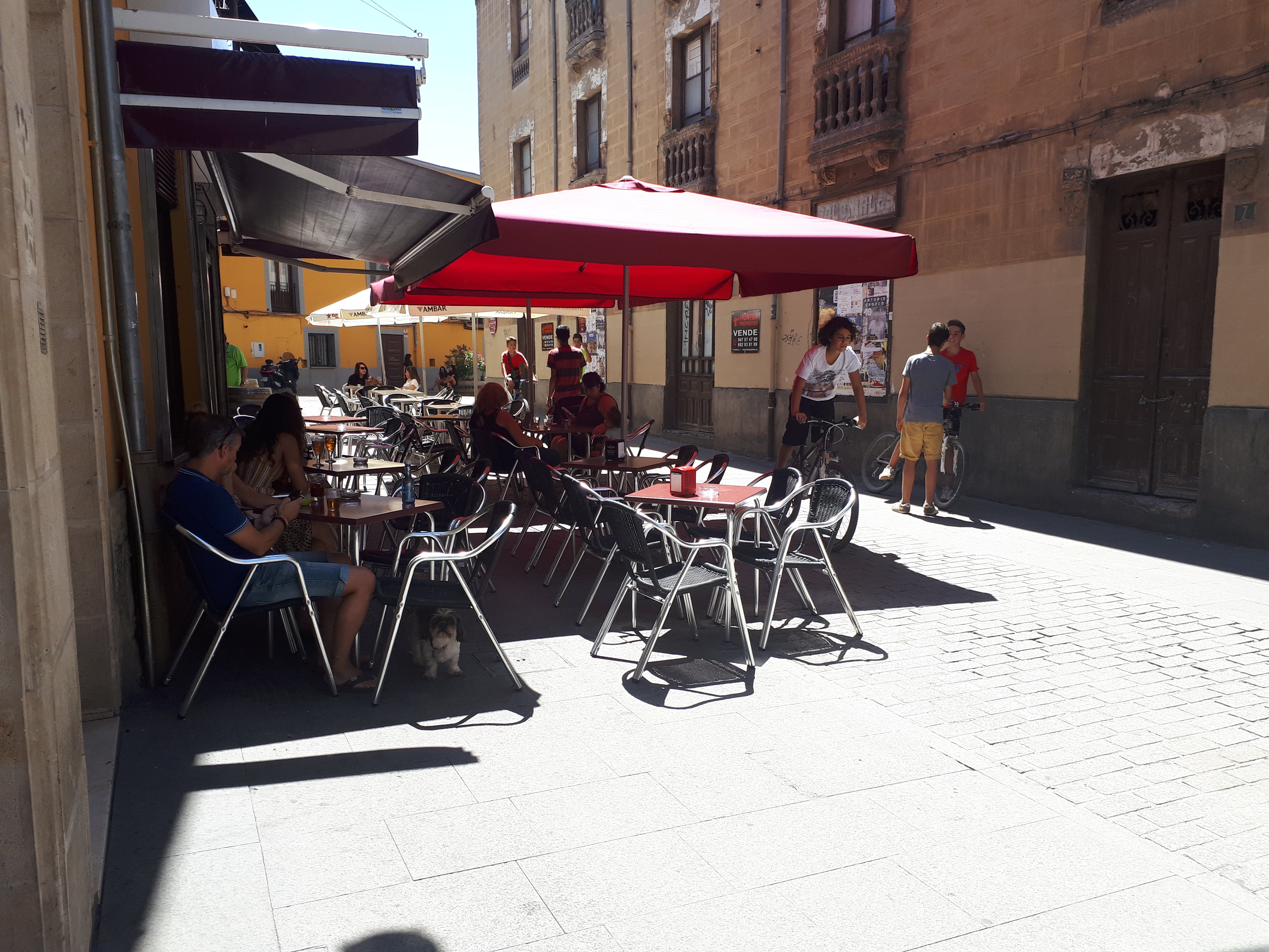 Varias personas toman un refresco en una terraza.