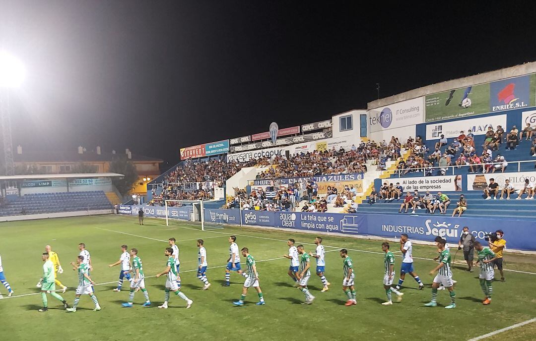 Salida de los dos equipos y trio arbitral, antes del encuentro entre el CD Alcoyano y el Betis Deportivo, ante la mirada del público de El Collao.