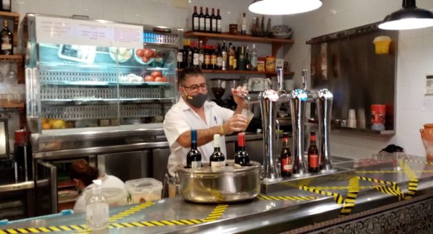 Un camarero sirve cerveza en un bar de Sevilla