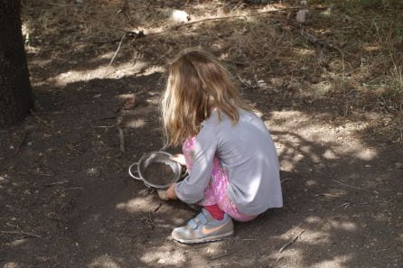 Una niña juega con el barro.