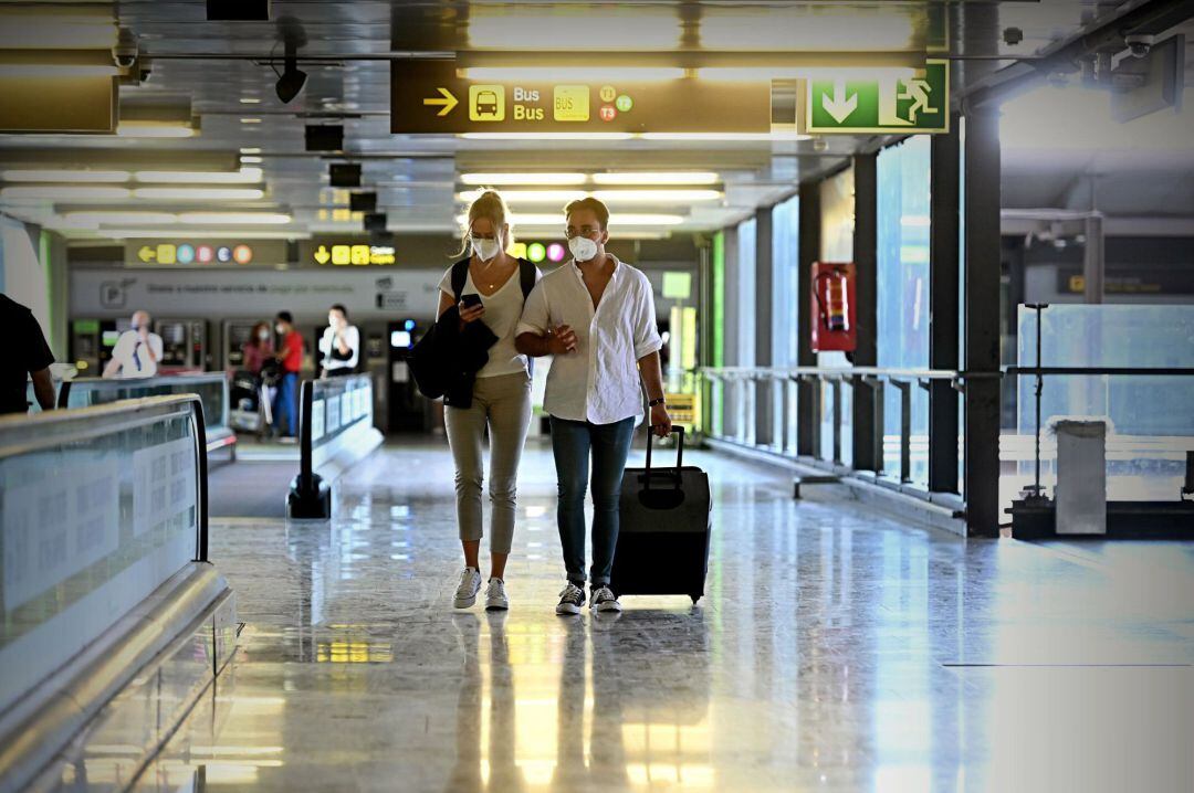 Varios turistas caminan por la terminal 4 del Aeropuerto de Barajas