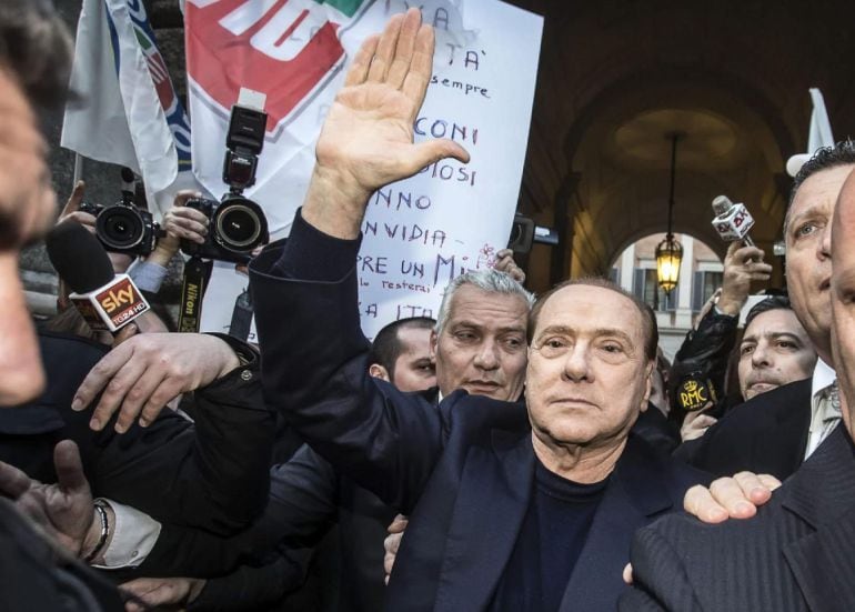 El ex primer ministro italiano Silvio Berlusconi saluda a sus seguidores a su llegada al Palazzo Grazioli en Roma