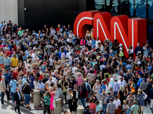 Empleados del grupo posan delante de la puerta de la CNN en EEUU.
