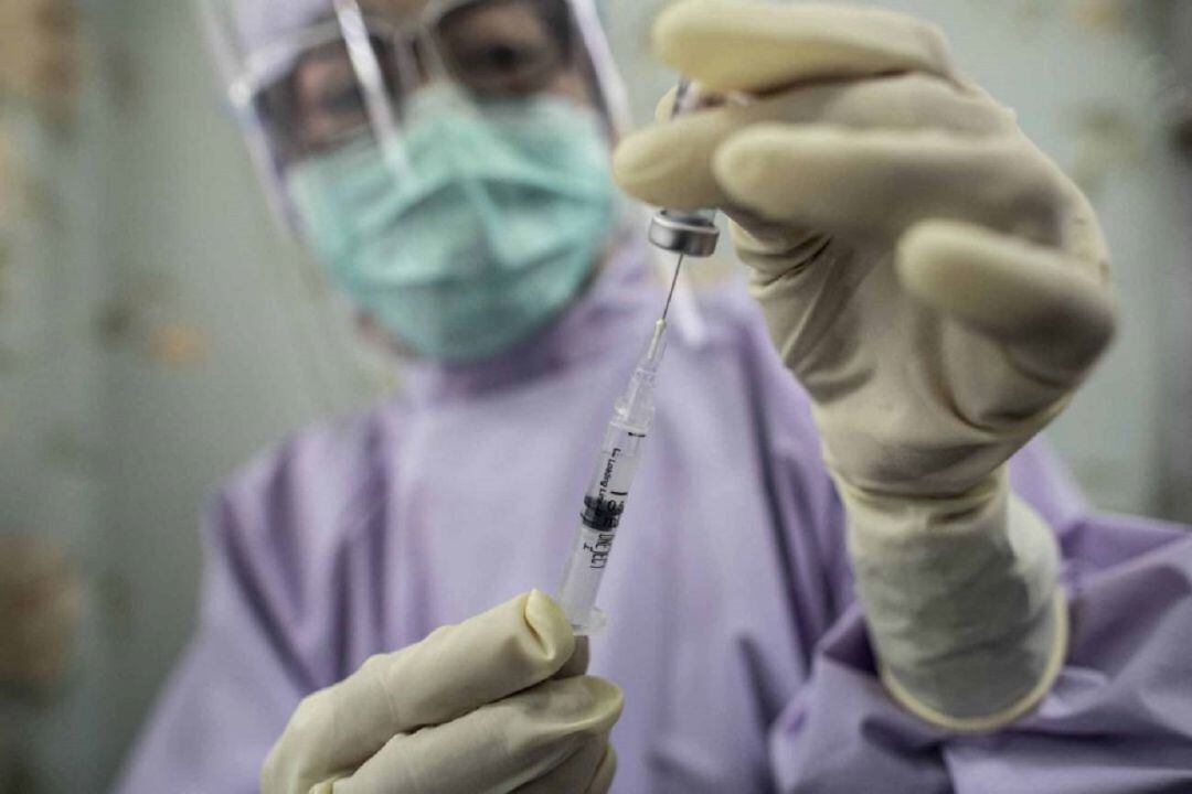 Una sanitaria suministra una vacuna.