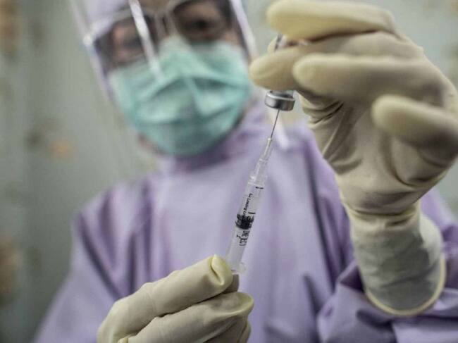 Una sanitaria suministra una vacuna.