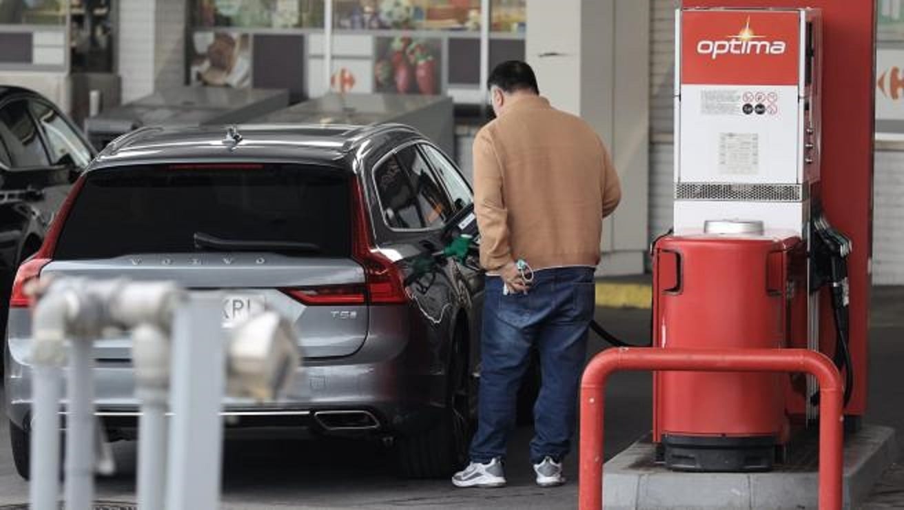 Un hombre repostando en una gasolinera.