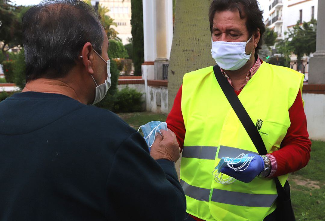 Un operario entrega una mascarilla en el centro de Jerez