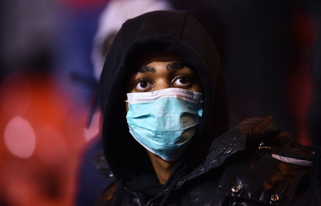 Aficionada de un partido de fútbol con mascarilla por el coronavirus