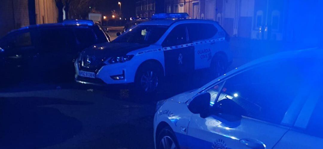 Los coches de Policía Local y Guardia Civil de Valdemoro apostado a las puertas de la nave que desalojaron.