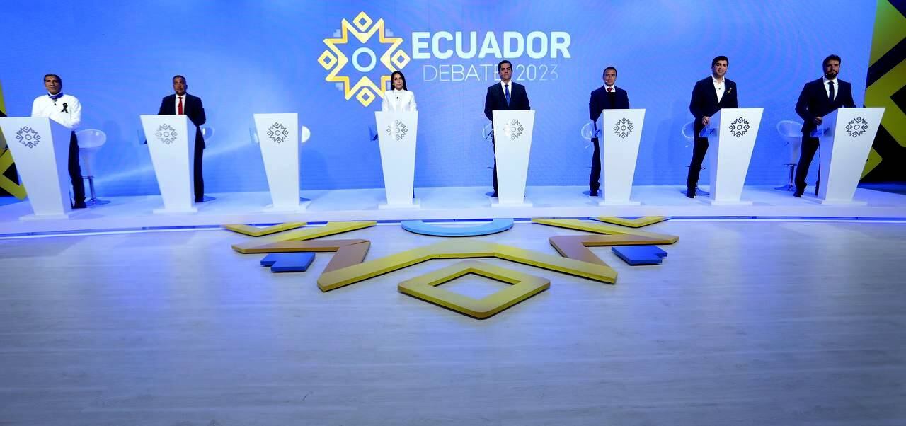 Los candidatos a la Presidencia que participan en el debate del canal EcuadorTV, con el atril de vacío de Villavicencio