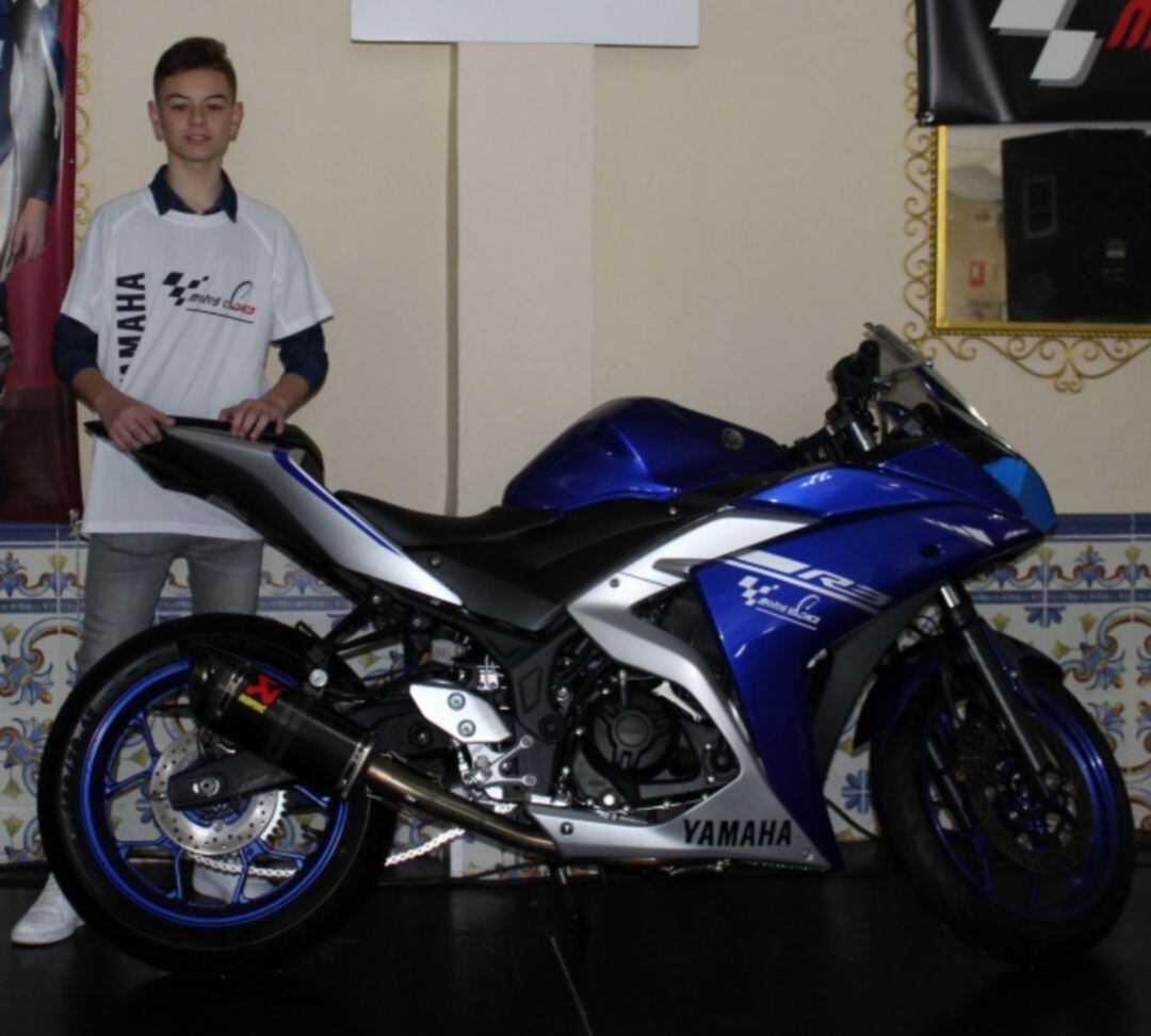 Marcos Garrido posando junto a la motocicleta con la que competía