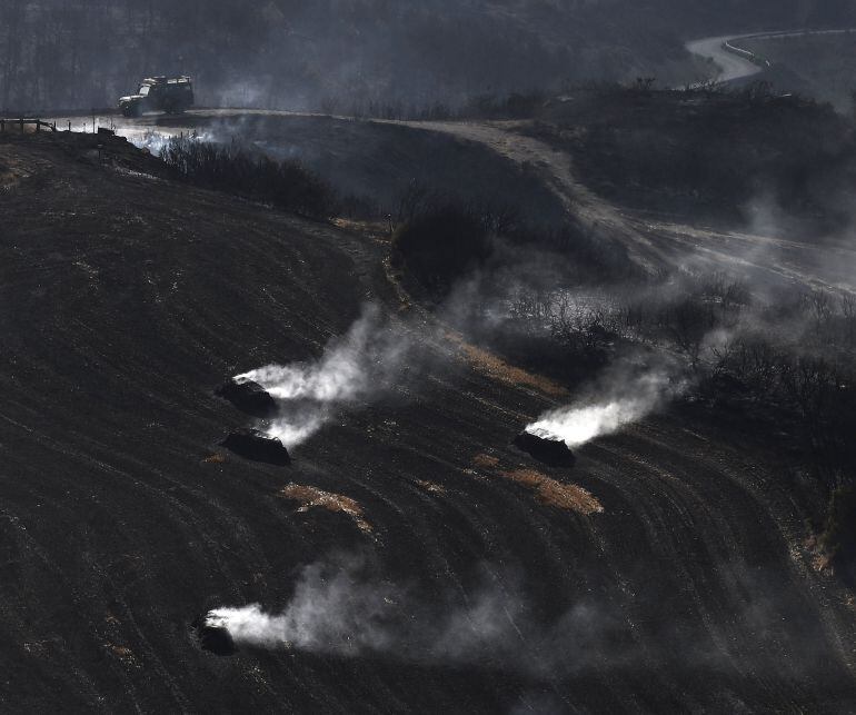 Pacas de paja aún humeantes por el incendio declarado este jueves entre las localidades de Tafalla y Pueyo.