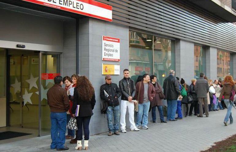 Ciudadanos esperando ante una oficina de empleo.