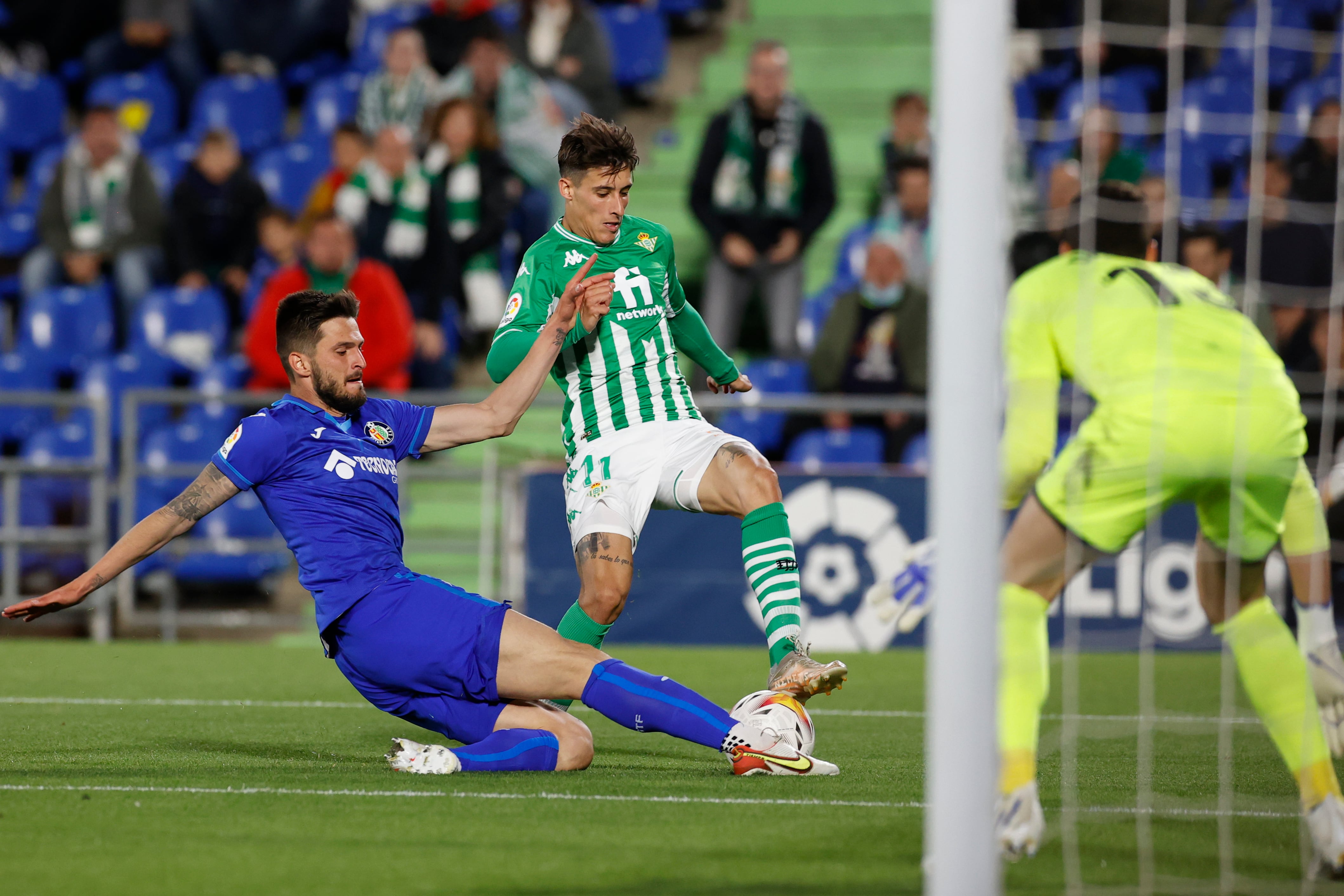 GETAFE (MADRID), 02/05/2022.- El delantero del Betis Cristian Tello (c) trata de salvar la entrada de Okay Yokuslu (i), del Getafe, durante el partido de Liga en Primera División que disputan este lunes en el estadio Coliseum. EFE/Juan Carlos Hidalgo