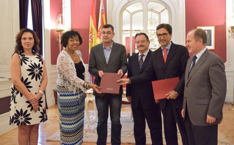 El president de les Corts, Enric Morera, entrega a la delegación de la Unesco una copia de la declaración institucional para que Valencia sea Ciudad de la Seda 2016