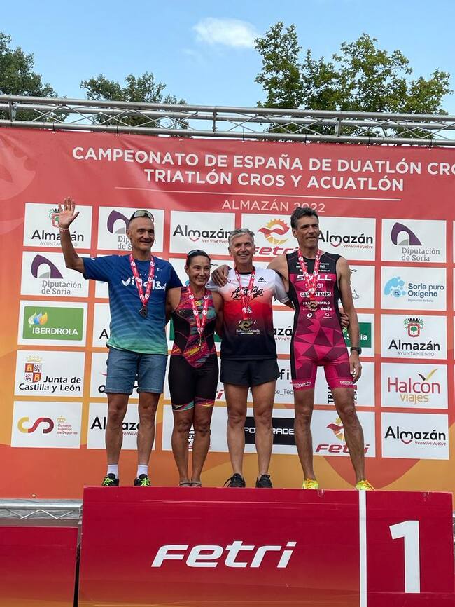 Luis Villán (2º por la dch) en el podio como campeón de España de triatlón cross Máster 50-55