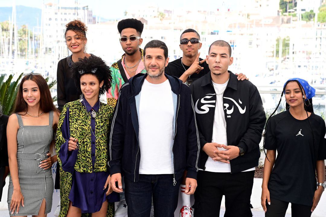 CANNES, FRANCE - JULY 16: (Top L to R) Amina Kannan, Ismail Adouab and Mehdi Razzouk (Front L to R) Nouhaila Arif, Zineb Boujemaa, Director Nabil Ayouch, Anas Basbousi and Samah Barigou attend the &quot;Haut Et Fort (Casablanca Beats)&quot; photocall during the 74th annual Cannes Film Festival on July 16, 2021 in Cannes, France