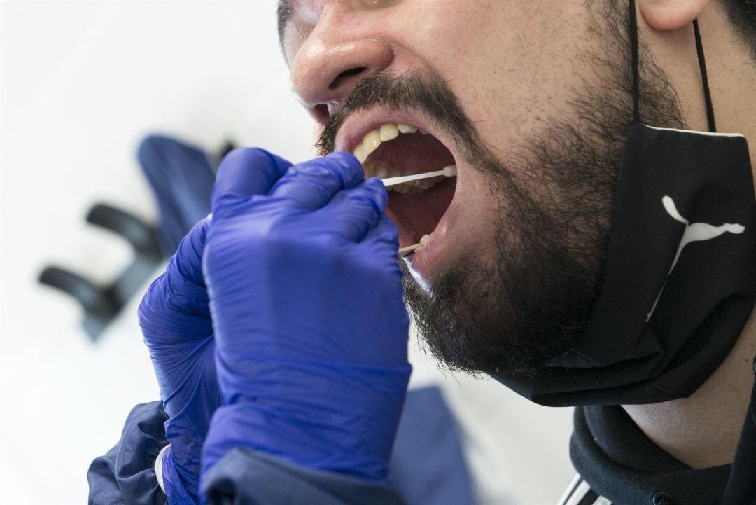 Un sanitario realiza una prueba PCR a un paciente.