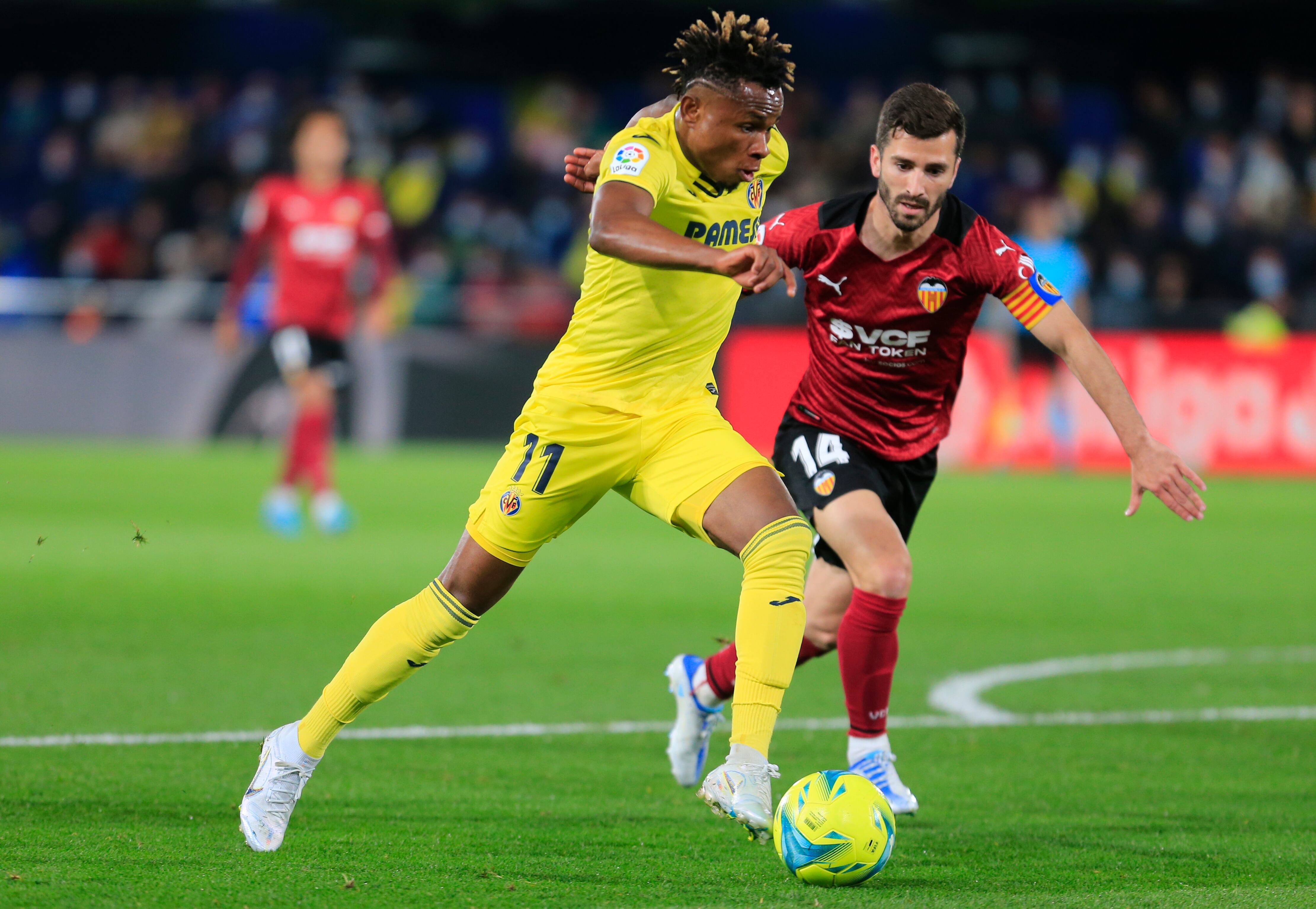 VILLARREAL (CASTELLÓN), 19/07/2022.- El delantero nigeriano del Villarreal, Samuel Chukwueze (i), conduce el balón ante el defensa del Valencia, José Gayá, durante el encuentro correspondiente a la jornada 33 de primera división disputado hoy martes en el estadio de La Cerámica, en la localidad castellonense. EFE / Domenech Castelló.
