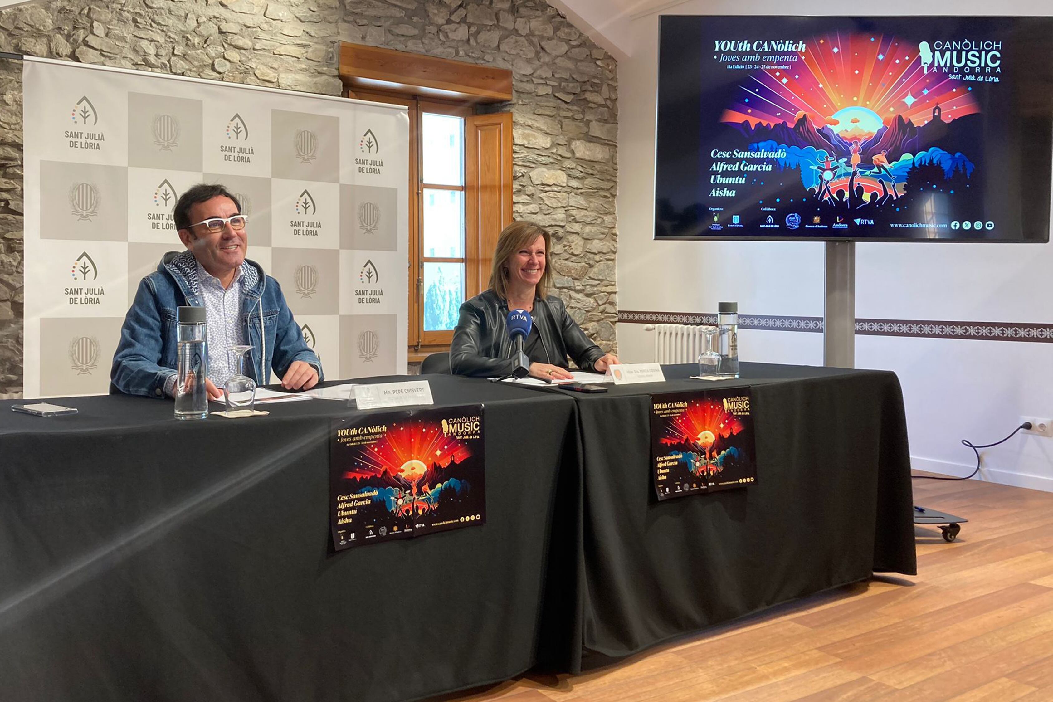 El rector de la parròquia de Sant Julià de Lòria, mossèn Pepe Chisvert i la cònsol menor del comú de Sant Julià de Lòria, Mireia Codina, durant la roda de premsa de presentació de l'onzena edició del Canòlich Music Festival.