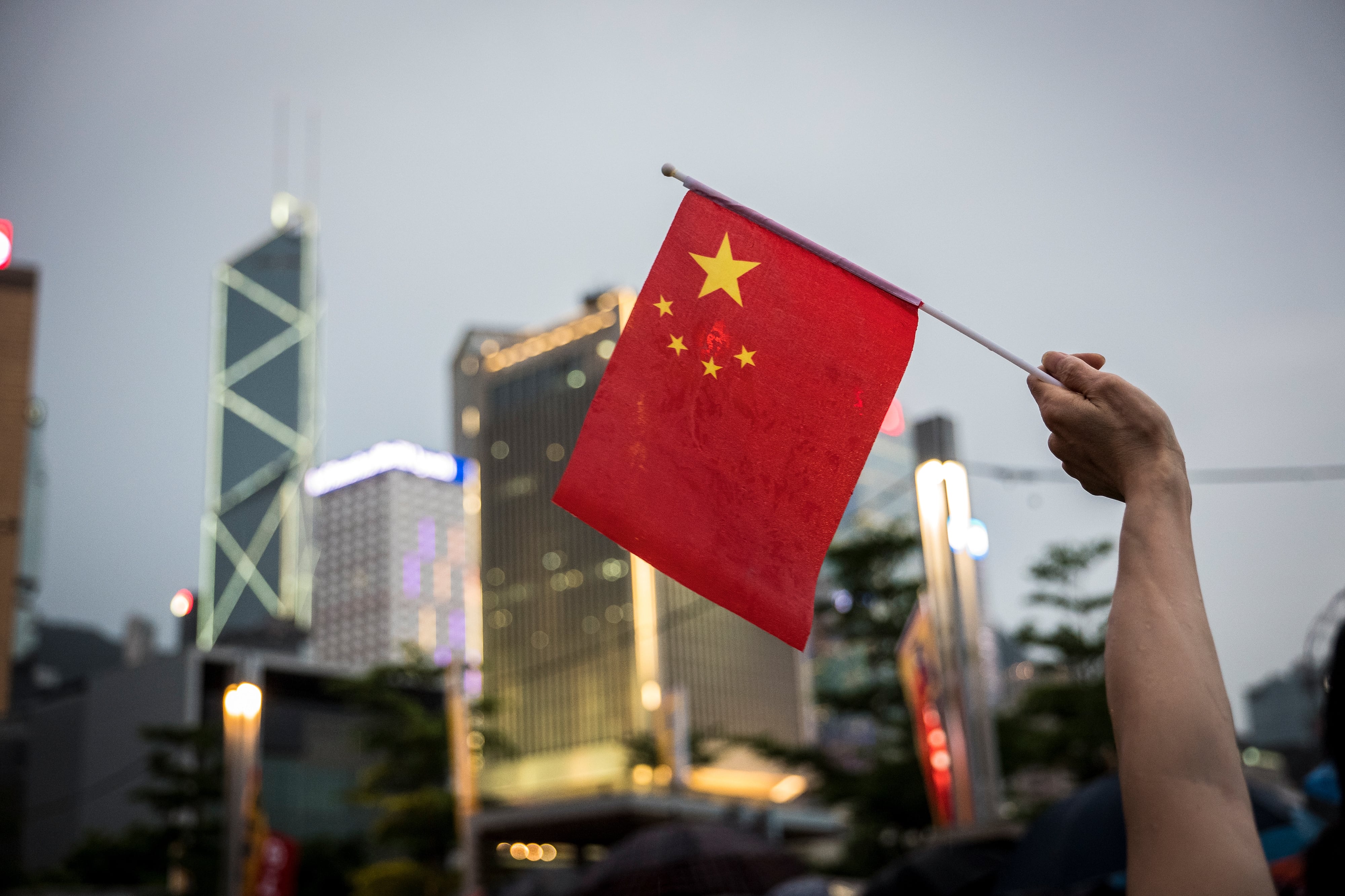 Un hombre ondea una bandera de China en Hong Kong.