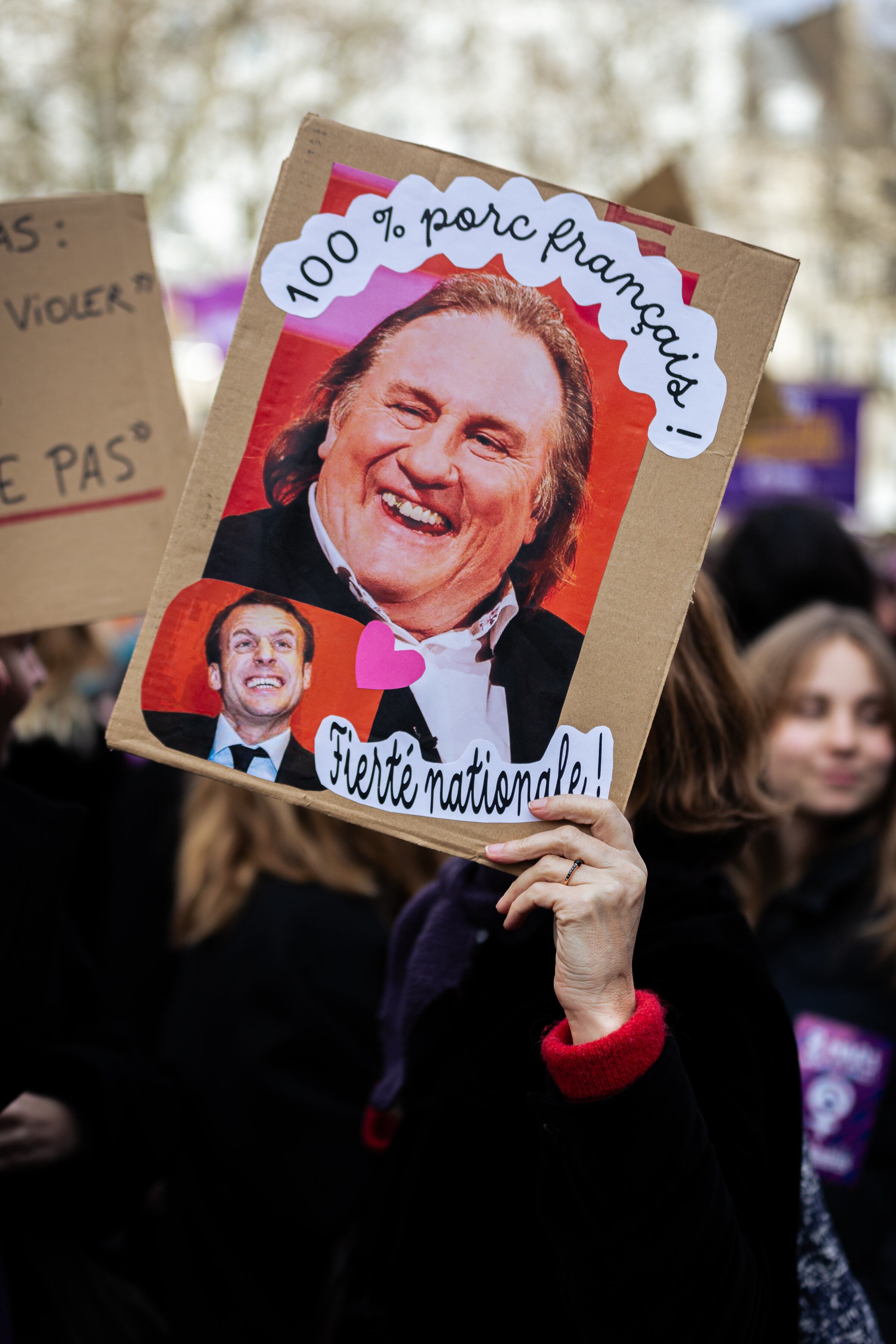 Una mujer sostiene un cartel con la imagen de Gérard Depardieu que dice "100% cerdo francés" durante la manifestación del Día Internacional de la Mujer. Getty Images.
