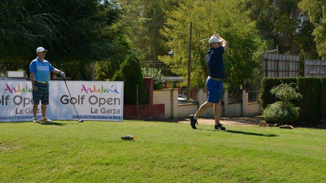 Dos personas juegan al golf en el campo de la Garza de Linares.