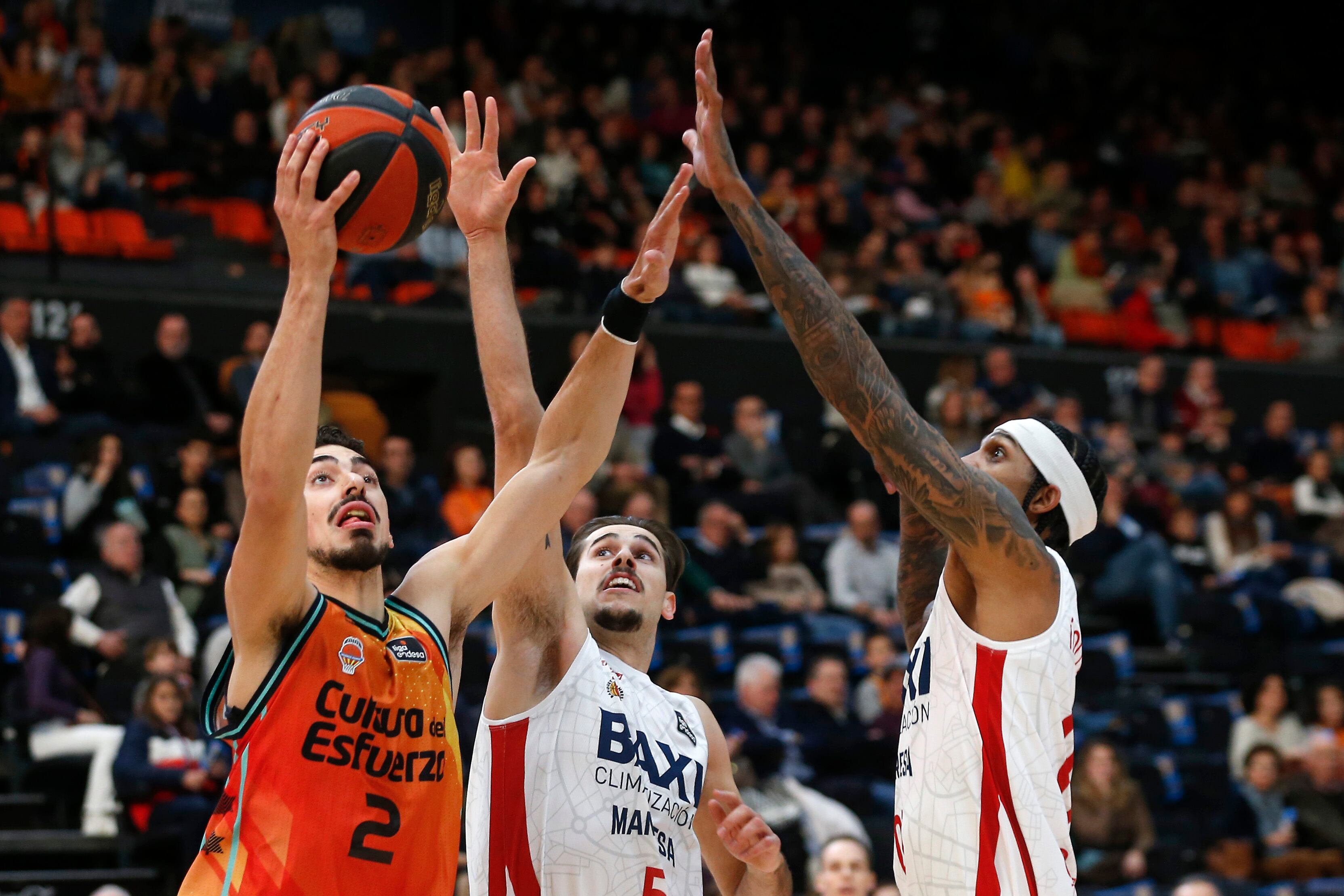VALENCIA, 15/01/2023.- El alero español de Valencia Basket Josep Puerto (i) lanza a canasta ante la oposición de Guillem Jou (c) y Devin Robinson, escolta y alero del Bàsquet Manresa, durante el partido de la jornada 16 de la Liga Endesa entre el Valencia Basket y el Bàsquet Manresa disputado este domingo en el pabellón Fuente de San Luis de Valencia. EFE/ Miguel Ángel Polo
