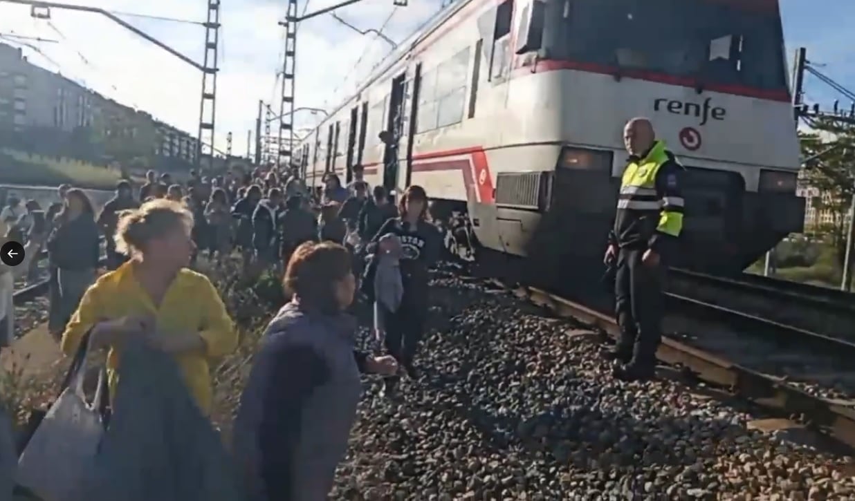 Pasajeros andando por las vías del tren tras la incidencia en Cercanías Madrid