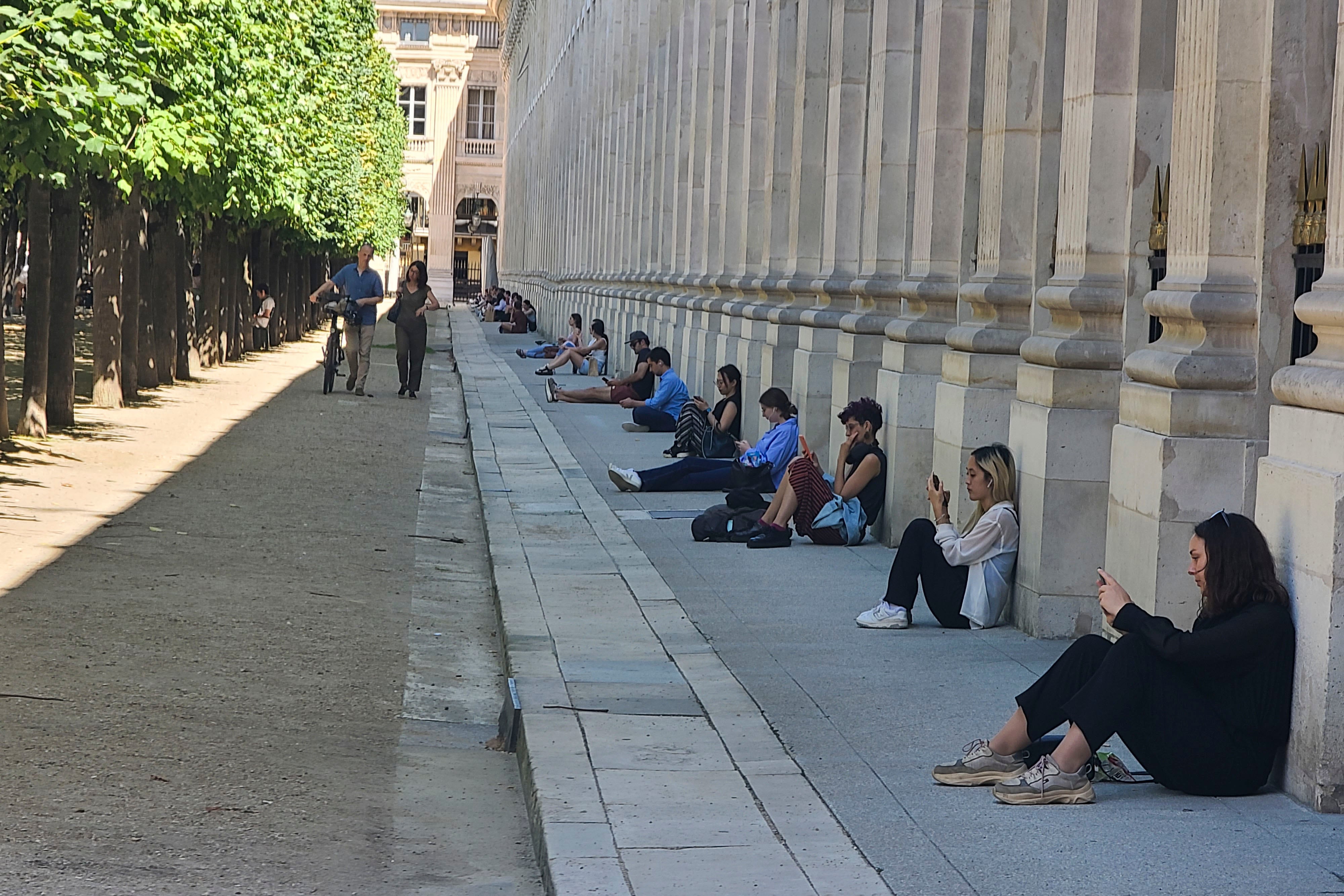 PARÍS, 21/08/2023.- Los servicios meteorológicos franceses prevén que estos próximos días, con más de medio país en alerta por la ola de calor, se corre el riesgo de superar algunos récords de temperatura, en particular el martes y el miércoles en el valle del Ródano, donde el fin de semana ya se superaron los 40 grados celsius. En la imagen, un grupo de personas se refugia del calor este lunes en las inmediaciones del jardín del Palacio Real de París. EFE/ Edgar Sapiña Manchado
