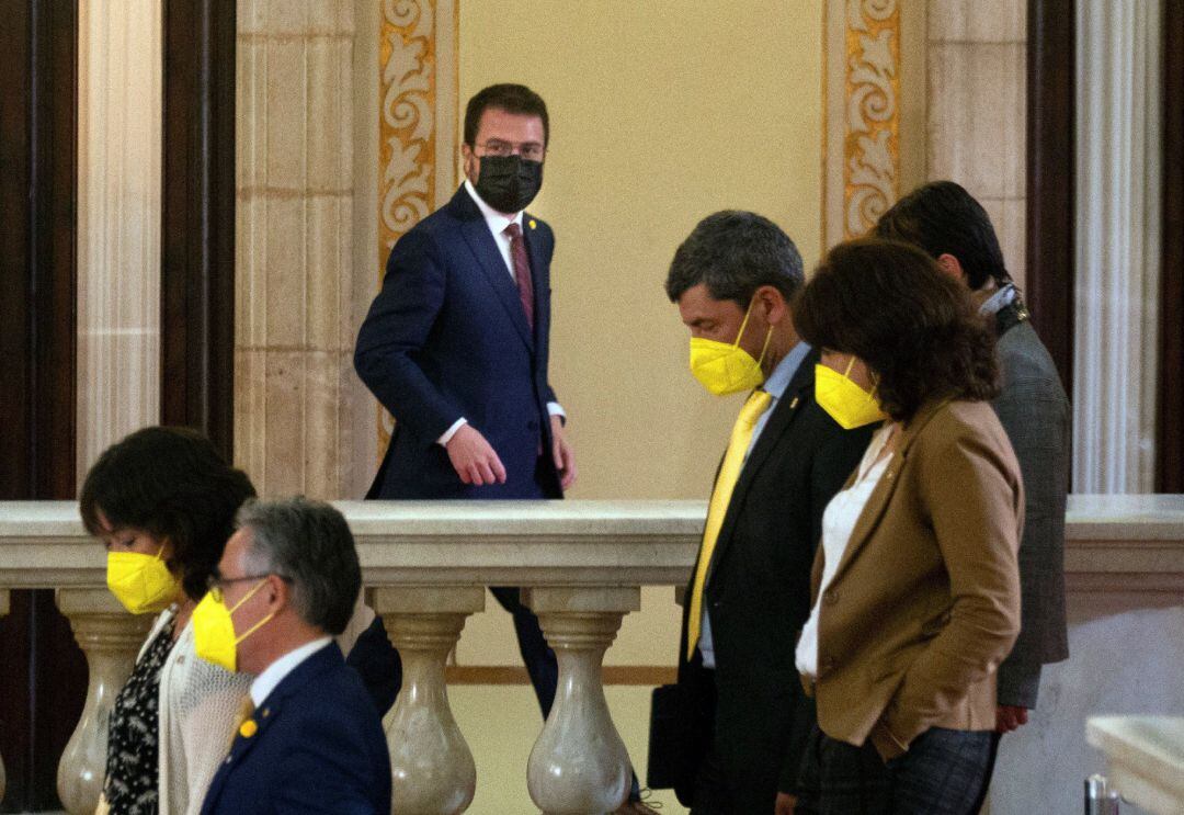 El candidato de ERC, Pere Aragonés, junto a varios diputados de JxCat, en los pasillos del Parlament.